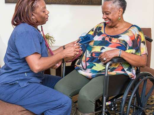 A caregiver helping a woman in a wheelchair