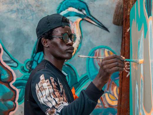 An artist painting a colourful mural